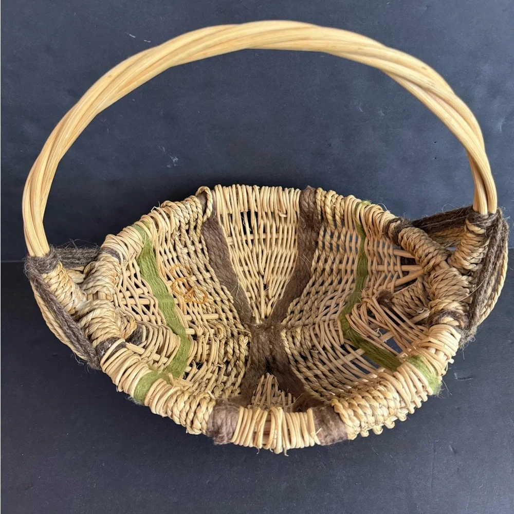 Vintage handwoven basket with brown and green yarn details and eye of God.